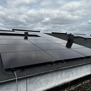 Deze installatie toont zonnepanelen die op een plat dak zijn gemonteerd voor het opwekken van zonne-energie.
