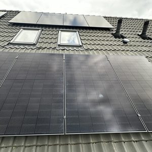 Een installatie van zonnepanelen op een hellend dak, voorzien van meerdere panelen voor optimale energieopbrengst.